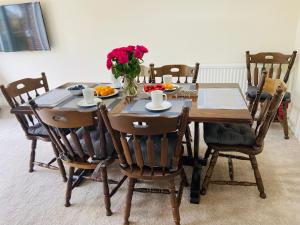 uma mesa de jantar com um vaso de flores em Cambridge Stays 3BR House-Garden-Free Parking-15 min to centre-5 min to motorway em Cambridge