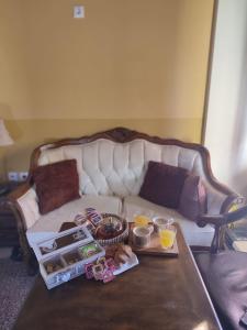 a coffee table with food and drinks on a couch at Evergreen Suites in Synikia Mesi Trikalon
