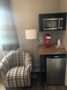 ein Wohnzimmer mit einem Stuhl und einer Mikrowelle in der Unterkunft 7 Day's Hotel in Lamont