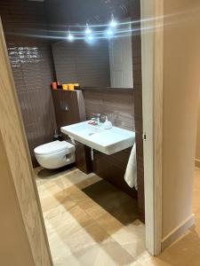 ein Badezimmer mit einem weißen Waschbecken und einer Toilette in der Unterkunft La casita del bosque in Lugo + 12 Fotos