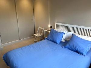 ein blaues Bett mit blauen Kissen im Schlafzimmer in der Unterkunft La casita del bosque in Lugo