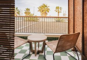 a balcony with a table and chairs and palm trees at Hotel Casa Bassa in Valencia