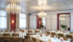 a dining room with tables and chandeliers at Hotel Rössli in Basel