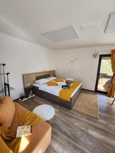 a bedroom with a bed and a couch at The Sun Chalet by Touch the Sky in Moieciu de Jos