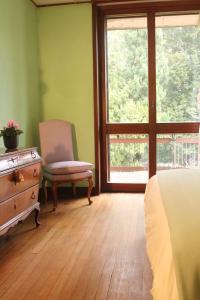 1 dormitorio con 1 cama, 1 silla y 1 ventana en Villa Inella, en Oggiono