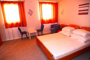 a bedroom with a bed and chairs and windows at Koblenzerstraße 16 in Bad Ems