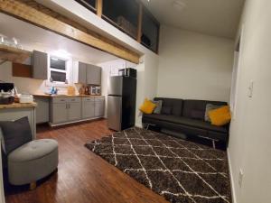 a living room with a couch and a kitchen at The Cozy Caribou - Frontier Village in North Pole