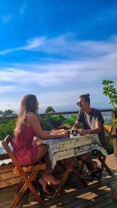 a man and a woman sitting at a picnic table at Loft Com Lago Hidro e Vista Para o Mar in Florianópolis