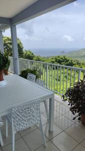 een veranda met een witte tafel en stoelen op een balkon bij Bel appartement de 250 m² dans un coin de paradis in Marigot