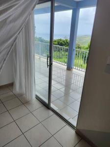 een glazen schuifdeur met uitzicht op een balkon bij Bel appartement de 250 m² dans un coin de paradis in Marigot