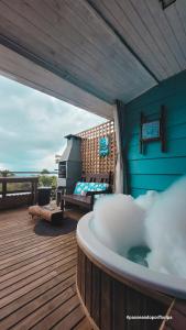 uma banheira de hidromassagem sentada num deque com uma cama em Loft Com Lago Hidro e Vista Para o Mar em Florianópolis