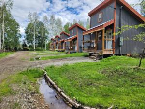 uma fila de casas num campo com uma estrada de terra em The Lazy Lynx - Frontier Village em North Pole