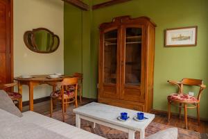 a living room with green walls and a table and a cabinet at Taylor's Port [3] Landing in the Old Town in Montevideo
