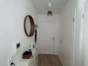 ein weißes Badezimmer mit einem Spiegel und einer Tür in der Unterkunft Appartement T2 -Parking -35Min Paris RER 2Min à Pied in Évry-les-Châteaux