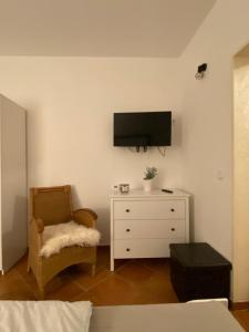 a living room with a tv on the wall and a chair at Apartment mit Terrasse iP-TV Stellplatz in Krefeld