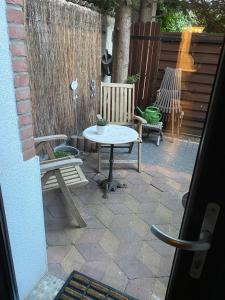 un patio con 2 bancos, mesa y sillas en Apartment mit Terrasse iP-TV Stellplatz, en Krefeld