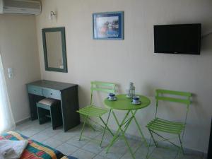 a room with a table and two chairs and a television at Villa Teozenia in Achladies