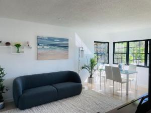 a living room with a blue couch and a table at Vacation House 2-Bedroom 1 Bathroom in Beach Town with Full size Kitchen and free onsite parking and laundry - Great for solo, couple, family and business travelers in Manhattan Beach