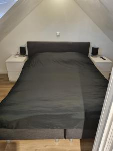 a bed in a room with two night stands at Calm Down Near The Sea in Vlissingen