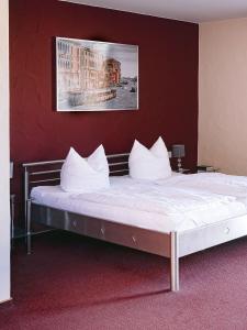 Cette chambre comprend un grand lit avec des oreillers blancs. dans l'établissement Hotel Landgasthof Zur Alten Scheune, à Zweibrücken