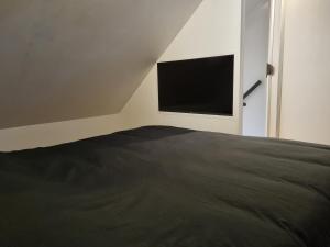 a bedroom with a bed and a flat screen tv at Calm Down Near The Sea in Vlissingen +2 photos