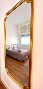 einen Spiegel, der ein Bett im Schlafzimmer reflektiert in der Unterkunft ANGELILLO DREAMS in Madrid
