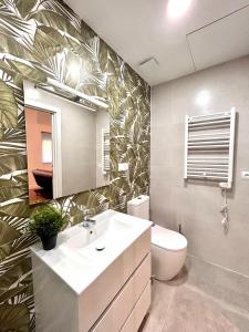 ein Badezimmer mit einem Waschbecken, einem WC und einem Spiegel in der Unterkunft ANGELILLO DREAMS in Madrid