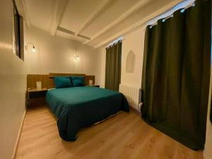 Schlafzimmer mit einem Bett mit grüner Tagesdecke in der Unterkunft Sydel2 in Paris