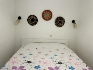 a bedroom with clocks on the wall and a bed at City Center Studio Apartment in Gjakove