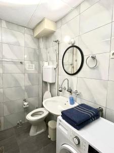 La petite salle de bains est pourvue de toilettes et d'un lavabo. dans l'établissement City Center Studio Apartment, à Gjakove