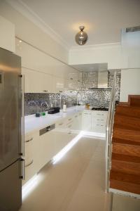 uma cozinha branca com armários brancos e uma escadaria em Kaplan Luxury Flat - 3 Bedrooms with air conditioning & heating in the City em Istambul
