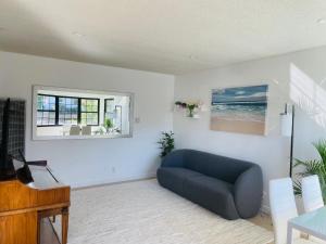 a living room with a blue couch and a window at Vacation House 2-Bedroom 1 Bathroom in Beach Town with Full size Kitchen and free onsite parking and laundry - Great for solo, couple, family and business travelers in Manhattan Beach