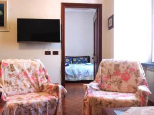 a living room with two chairs and a flat screen tv at Cuore di Mare in Levanto