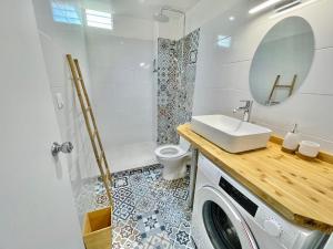 a bathroom with a sink and a washing machine at Appartement Belbo de la Marina in Les Trois-Îlets