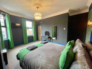 a bedroom with a large bed with green curtains at The Bedford Inn in Kent