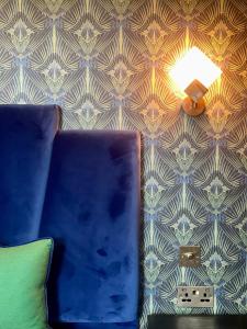 um quarto com uma almofada, um candeeiro e uma parede em The Bedford Inn em Kent