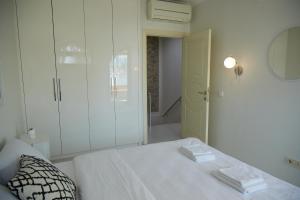 um quarto branco com uma cama e um espelho em Kaplan Luxury Flat - 3 Bedrooms with air conditioning & heating in the City em Istambul