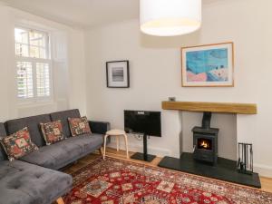 a living room with a couch and a fireplace at 6 Kirkstyle in Biggar