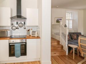 a kitchen and living room with white cabinets at 6 Kirkstyle in Biggar