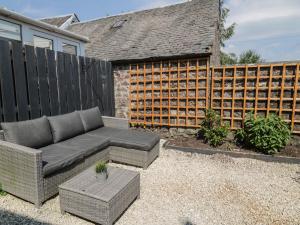 a patio with a couch and a fence at 6 Kirkstyle in Biggar