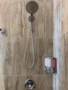 a shower with a shower head in a bathroom at Brooklyn Studios By The Beach in Brooklyn