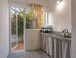 a kitchen with a sink and a window at Charm Bahia Suites in Arraial d'Ajuda