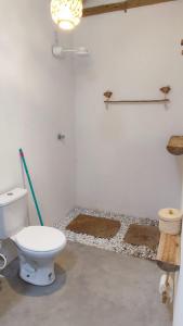 La salle de bains est pourvue de toilettes et de 2 tapis. dans l'établissement Villa Água Viva, à Itarema