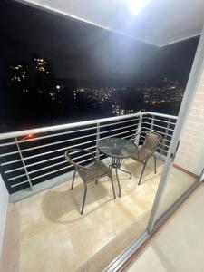 balcone con 2 sedie e tavolo di Apartamento en castropol a Medellín