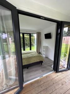 - une chambre avec un lit dans une pièce dotée de portes coulissantes en verre dans l'établissement De Texelaar, à Elspeet