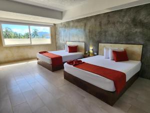 1 dormitorio con 2 camas y ventana en Sunsol Isla Caribe en El Agua