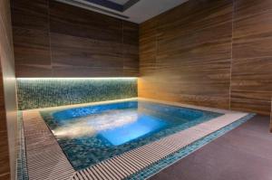 baño con piscina y paredes de madera en Apartman Gondola SPA II en Zlatibor