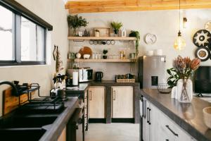 a kitchen with black counter tops and a refrigerator at Leopard's Khaya, Marloth Park in Marloth Park