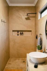La salle de bains est pourvue d'un grand lavabo blanc sur un comptoir. dans l'établissement Leopard's Khaya, Marloth Park, à Marloth Park