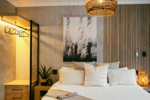 - une chambre avec un grand lit et des oreillers blancs dans l'établissement Leopard's Khaya, Marloth Park, à Marloth Park